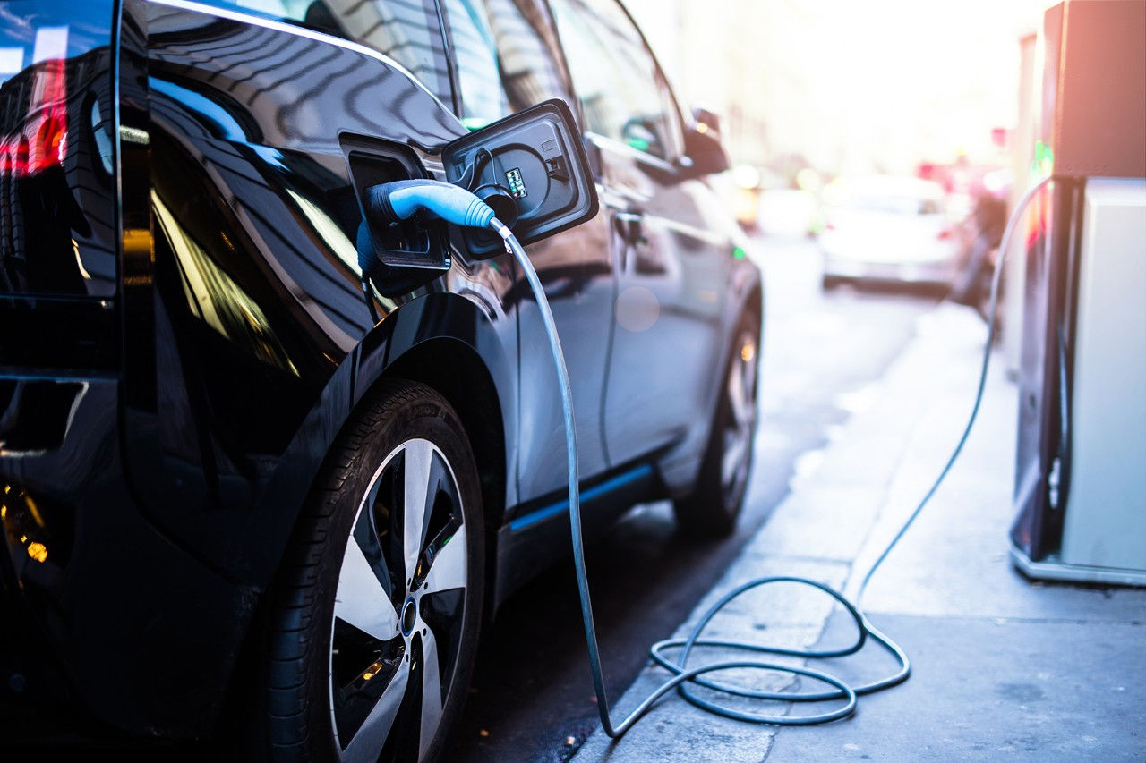 Electric vehicle being charged at charging station