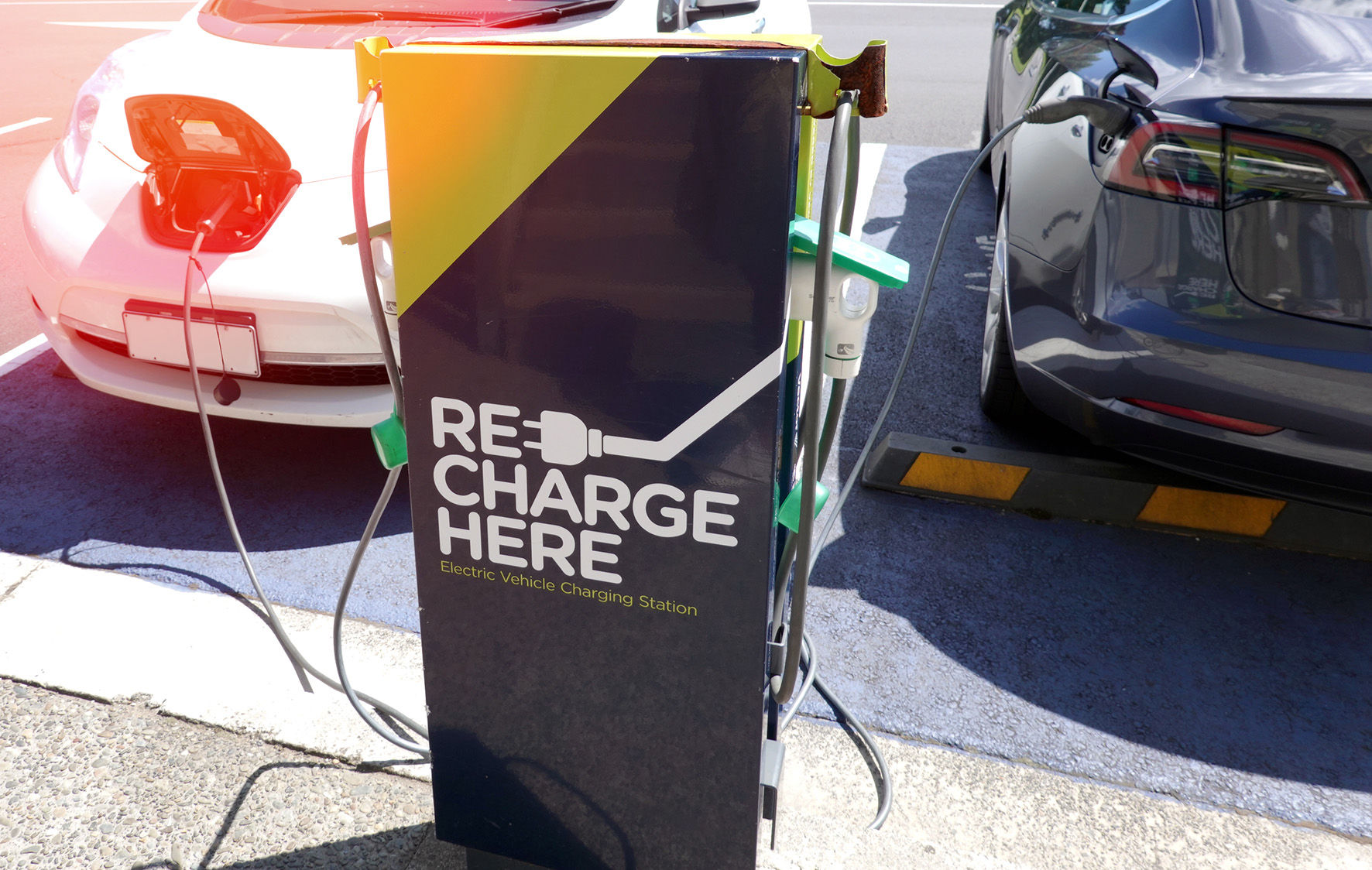 2 vehicles being charged at an electric vehicle charging station