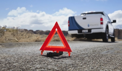 Warning Triangle on Road with Vehicle in Background